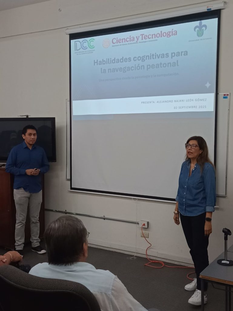 La Dra. María del Carmen Mezura Godoy dirigiéndose a los asistentes desde el escenario, con la proyección del título del seminario en pantalla.