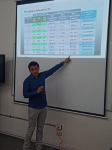 El Mtro. Alejandro Najani León Gómez señala una tabla de resultados proyectada en pantalla mientras explica su investigación sobre perfiles cognitivos de navegación.