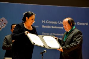 La rectora Sara Ladrón de Guevara y el guitarrista en el momento de la condecoración