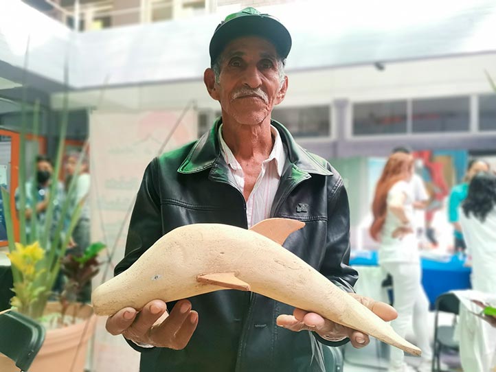 “Don Tiolino” exhibe una figura de delfín elaborada con madera de mangle