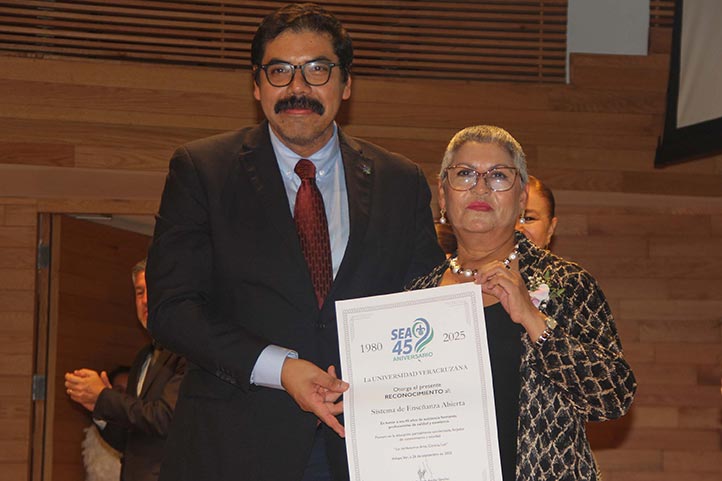 Arturo Aguilar Ye, secretario Académico, entregó el reconocimiento al SEA, que fue recibido por María Isabel Gómez 